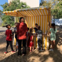 Eine Frau und sieben Kinder stehen beim Infostand vom himmelbeet beim Kieztag.