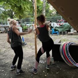 Zwei Menschen machen Stretching in Vorbereitung auf dem Hula-Hoop Workshop