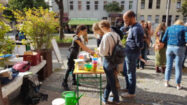 Eine Frau bietet Essen an auf einem Tauschmarkt in der Strasse