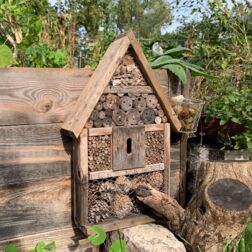 Insektenhotel aus Holz mit Bambus an einem Hochbeet gefestigt