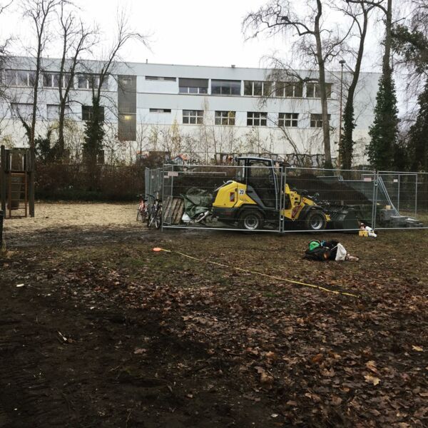 In der Gartenstraße am Spielplatz lagert jetzt die himmelbeet Erde,davor steht ein Radlader und ein Bauzaun