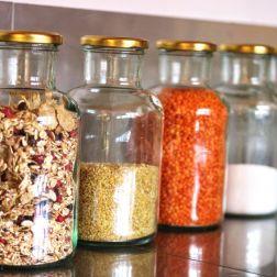 Ein Foto von großen Gläsern zur Aufbewahrung von Lebensmitteln. Sie sind z.B. gefüllt mit roten Linsen, Couscous und Salz.