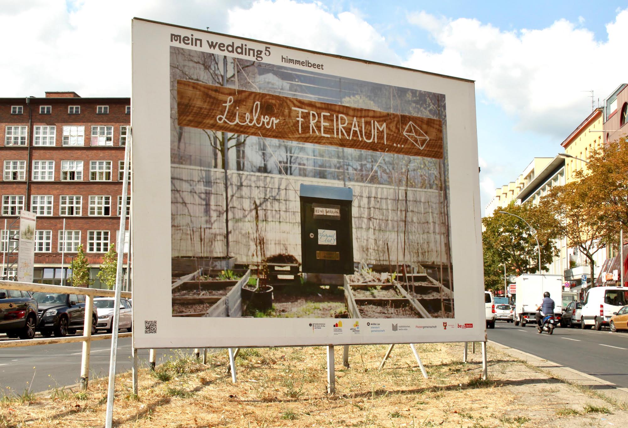 Ein Foto der Plakatwand auf der Müllerstraße, auf dem das Motiv "Lieber Freiraum" zu sehen ist: Ein Holzschild mit der Aufschrift "Lieber Freiraum", darunter ein Briefkasten mit himmelbeet-Logo & handgeschriebenem Zettel auf dem steht: "keine Werbung"